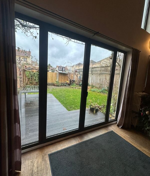 Baie vitrée aluminium posée par CapAlu, donnant sur un jardin